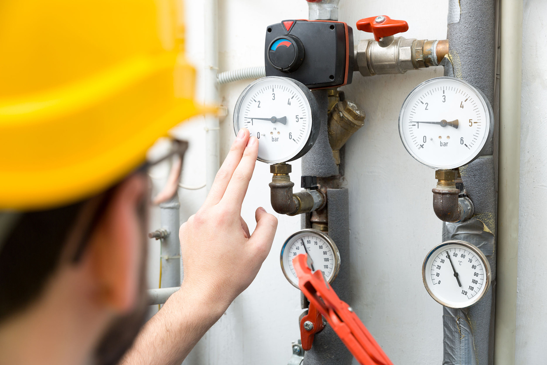 furnace tune-up - technician checking pressure meters for house heating system